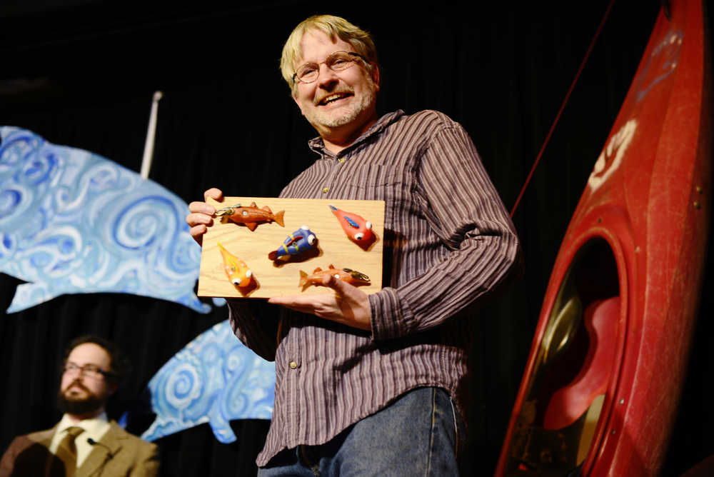 Ben Boettger/Peninsula Clarion Outgoing director of the Kenai Watershed Forum Robert Ruffner holds a "board of fish" (plastic toy fish bolted to a slab of wood) presented to him during an event in his honor on Saturday, January 9 at Kenai's Triumverate theatre. Governor BIll Walker nominated Ruffner to the Alaska Department of Fish and Game's Board of Fisheries in early 2015, but failed to be appointed during a series of controversial congressional confirmation hearings.