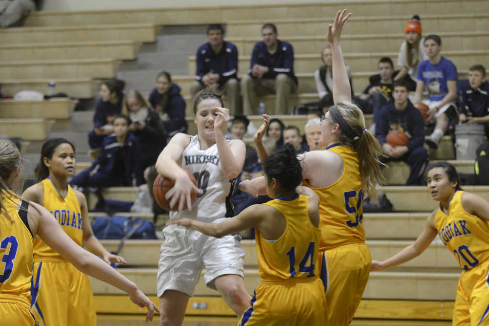 Photo by Jeff Helminiak/Peninsula Clarion Nikiski's Hallie Riddall tries to get a shot off against the defense of Kodiak's Nelly Hernandez (14) and Kathryn Carstens (50) on Thursday at Nikiski High School.