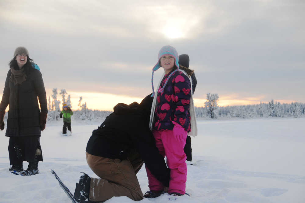 Photo by Elizabeth Earl/Peninsula Clarion Eden Alioto, 9, stops for her father to adjust her snowshoe before taking off across Headquarters Lake near the Kenai National Wildlife Refuge Visitor Center on Friday.