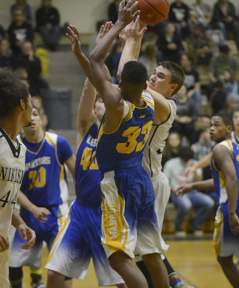 Photo by Joey Klecka/Peninsula Clarion Nikiski senior guard Sam Tauriainen looks for a teammate to pass to while being guarded by Bethel sophomore Clevon Constantine (33) Saturday at the Nikiski Tip-Off Tournament. The Bulldogs defeated Bethel 64-54 to win the championship.