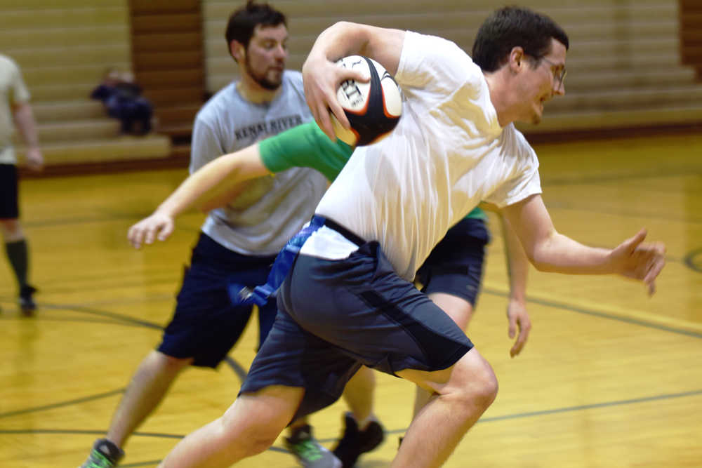 Ben Boettger/Peninsula Clarion Eric Hanneman attempts to pass Dustin Henkin (in green) at the Kenai Wolfpack Rugby club introductory clinic on Tuesday, Jan. 19 at Soldotna Prepatory School.