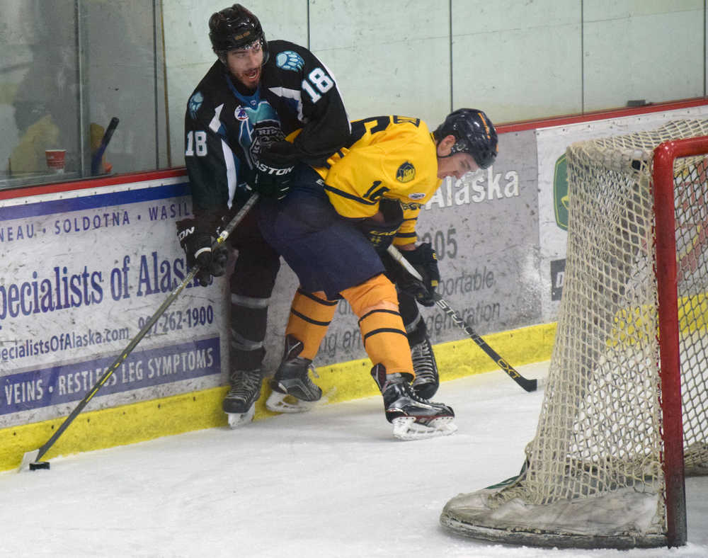 Photo by Jeff Helminiak/Peninsula Clarion Brown Bears forward Collin Appleton looks to make a play from behind the Jr. Blues net while Jr. Blues forward Matt Long keeps him pinned to the boards Friday, Jan. 22, 2016, at the Soldotna Regional Sports Complex.