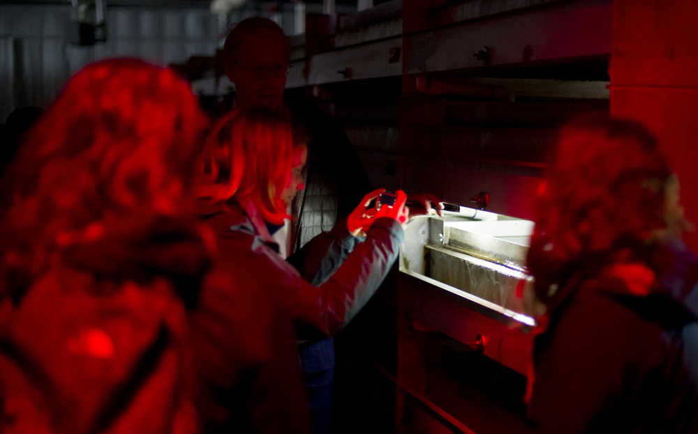 Allison Stopks of British Columbia takes a picture of salmon incubators during a tour of the Macaulay Salmon Hatchery on Wednesday. The tour is part of the Alaska Young Fishermen's Summit held in Juneau this week. (Photo by Michael Penn/Juneau Empire)