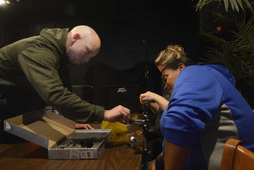 Photo by Megan Pacer/Peninsula Clarion Mark Wackler of the Trout Unlimited Kenai Peninsula Chapter assists LaDonna McCray, of Oklahoma, as she works on a fly duirng a class on Tuesday, Feb. 3, 2016 at the Main Street Tap and Grill in Kenai, Alaska.