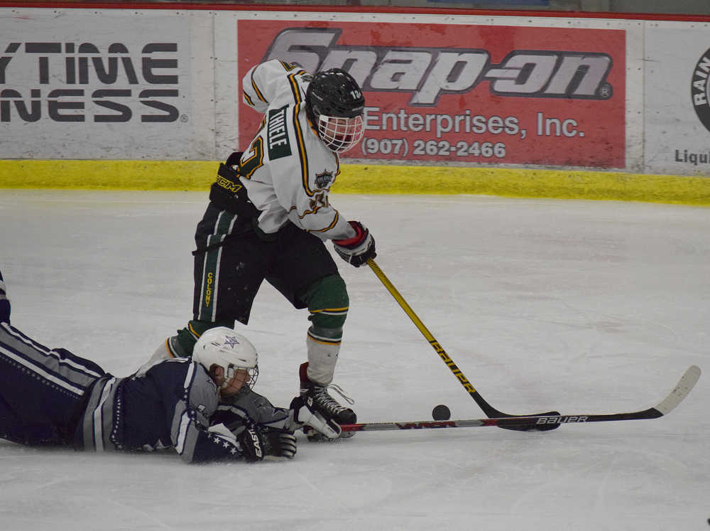 Photo by Joey Klecka/Peninsula Clarion Soldotna junior Ethan Brown dives for the puck against Colony junior Otto Thiele in Saturday's North Star Conference championship game at the Soldotna Regional Sports Complex. The Knights won 3-0.
