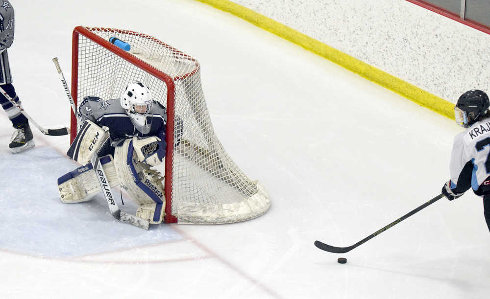 Photo by Joey Klecka/Peninsula Clarion Soldotna sophomore goalie Billy Yoder (left) tracks the puck with Chugiak junior Zach Krajnik in the second period of Thursday's Class 4A state hockey tournament quarterfinal.