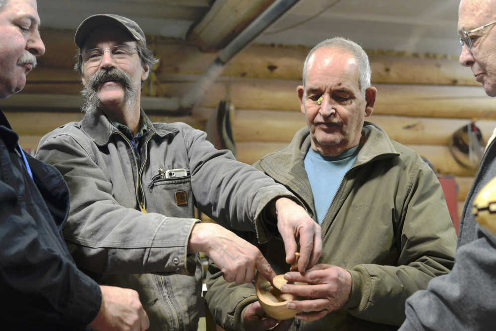 Members of the Kenai Peninsula Woodturners Chapter discuss the construction of a wooden bowl and lid during a meeting on Saturday, Feb. 13 near Soldotna.