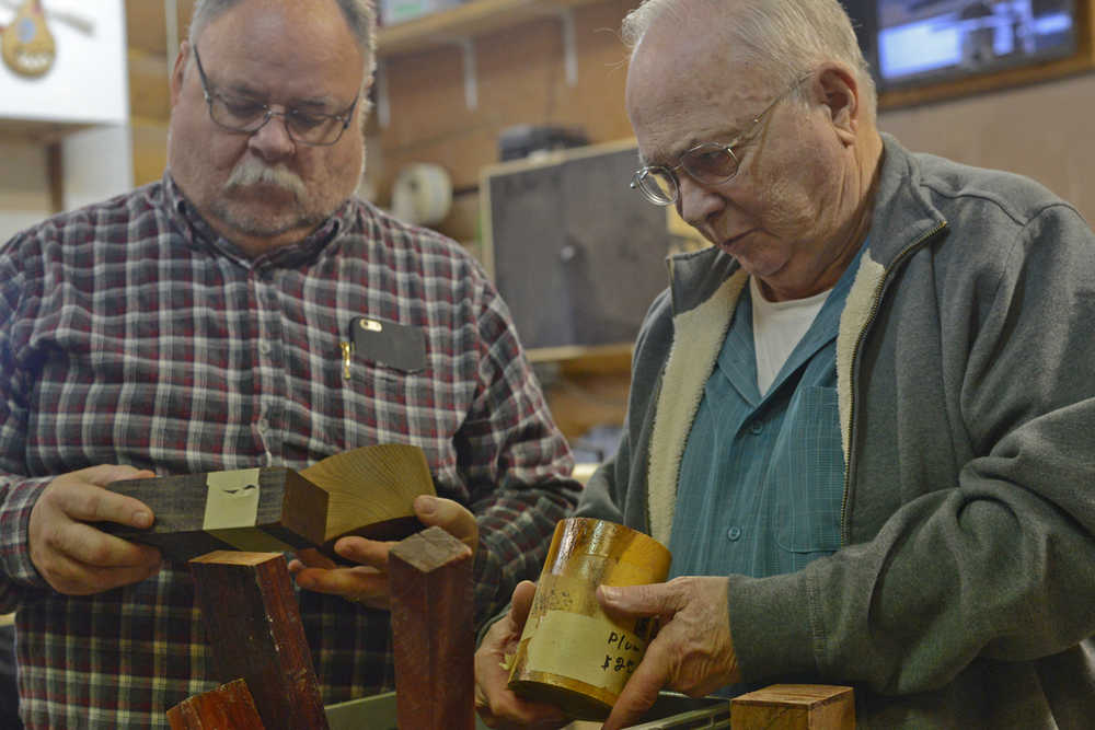 Lee Halstead (left) and Larry Pennington of the Kenai Peninsula Woodturners Chapter examine blocks of wood for sale at the group's monthly meeting on Saturday, Feb. 13 near Soldotna.