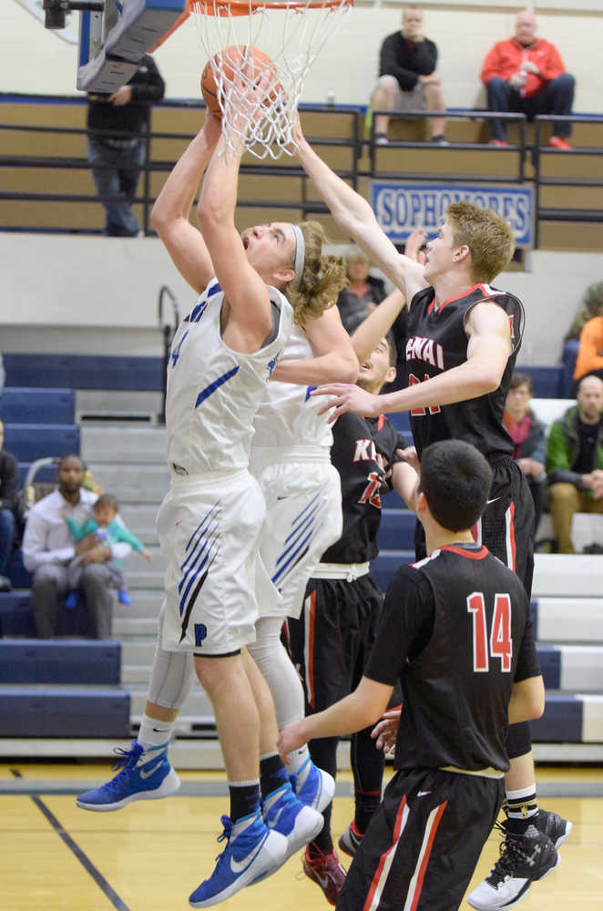 Photo by Joey Klecka/Peninsula Clarion Palmer senior forward Michael Kluting attempts a layup amid a scrum of Kenai Central players, including sophomore Garrett Fitt (right) and senior Marshall Vest (bottom), Saturday at Palmer High School. The Moose defeated the Kardinals 46-33.