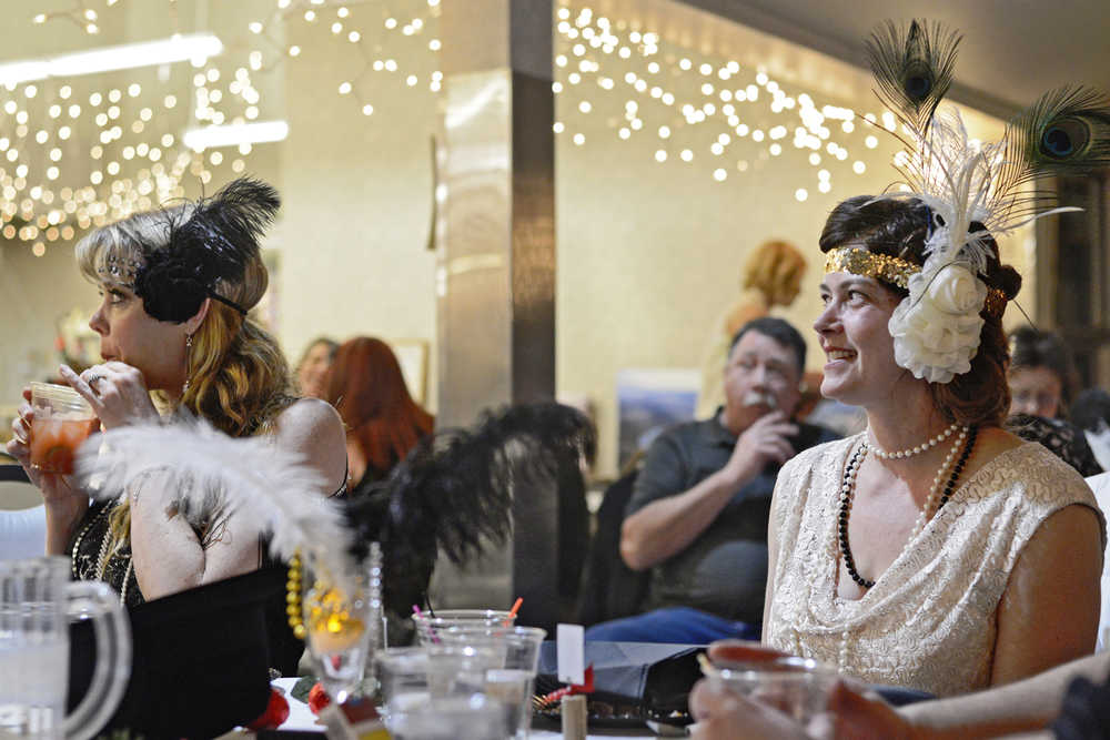 Jodi Crandall (left) and Heidi Meeham listen to comedian Dave Burroughs during a "Roaring '20s" themed dinner and comedy show charity event on Saturday, Feb. 13 at the Kenai Senior Center. The event, hosted by the Kenai Peninsula Association of Realtors, raised money for Habitat for Humanity and Hospice of the Central Peninsula.