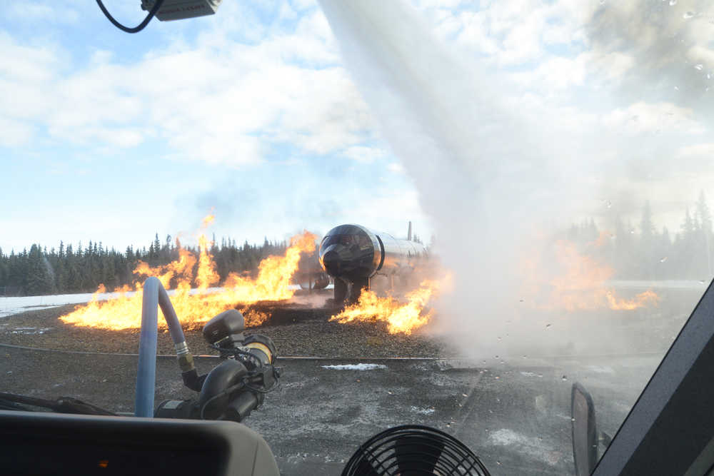 Kenai Fire Marshal Tommy Carver takes a turn using a fire engine to put out a simulated aircraft fire during an Aircraft Rescue and Firefighting drill on Monday, Feb. 15, 2016 at the Beacon Occupational Health and Safety Services Training Center in Kenai, Alaska.