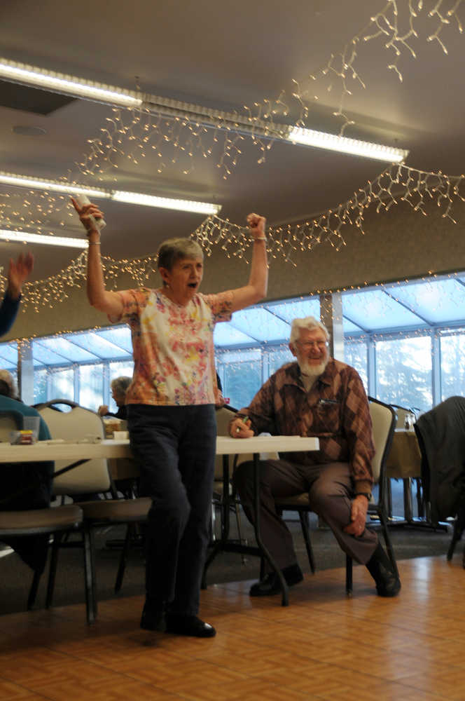 Photo by Elizabeth Earl/Peninsula Clarion Nita Douthit celebrates a strike during the Wii Bowling event of the Senior Olympics Tuesday, Feb. 16, 2016, at the Kenai Senior Center while Ray Nickelson keeps score.