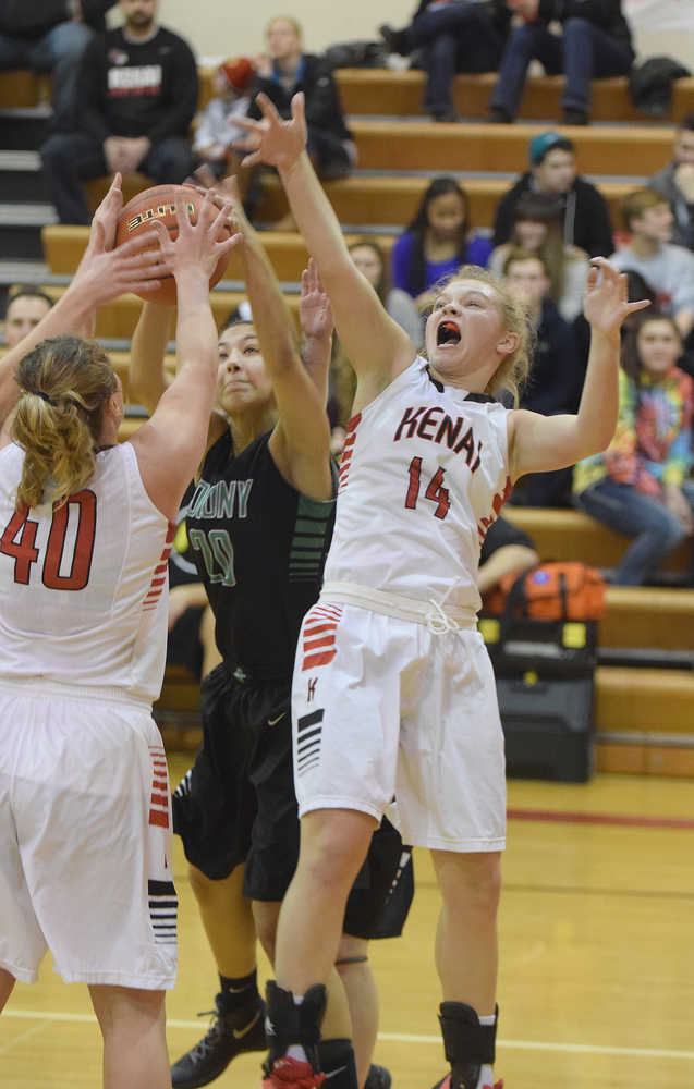 Photo by Joey Klecka/Peninsula Clarion Kenai Central forward Alli Steinbeck jumps for the rebound against Colony forward Chase Stephens (20) and Kenai teammate Abby Beck (40) Friday night at Kenai Central High School. The Kardinals lost to the Knights 36-26.