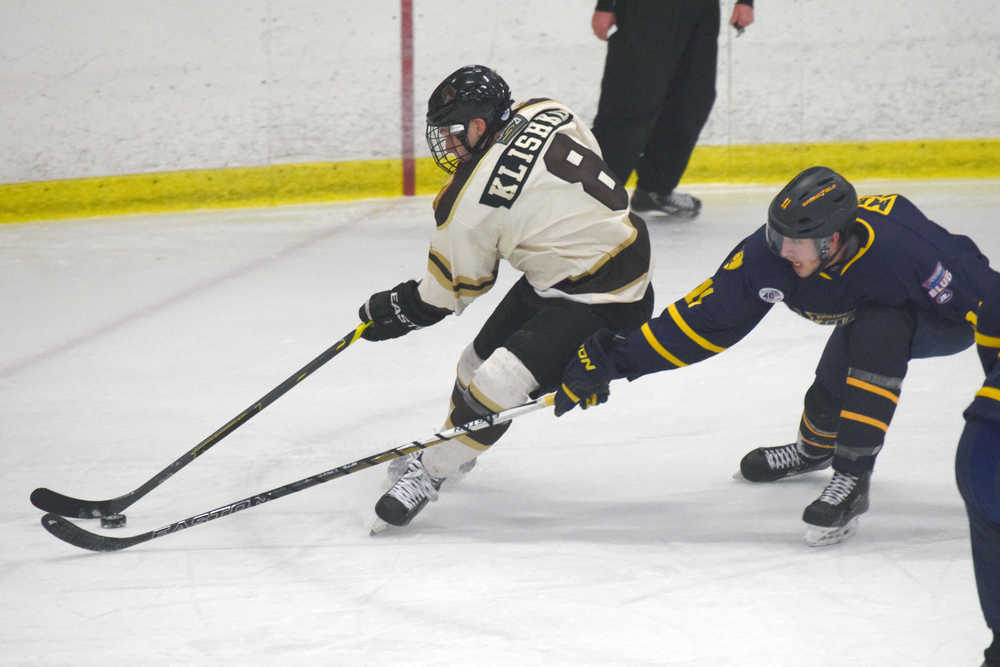 Photo by Jeff Helminiak/Peninsula Clarion Kenai River Brown Bears forward Nick Klishko drives the net on Springfield Jr. Blues defenseman Kyle Meeh on Friday at the Soldotna Regional Sports Complex.