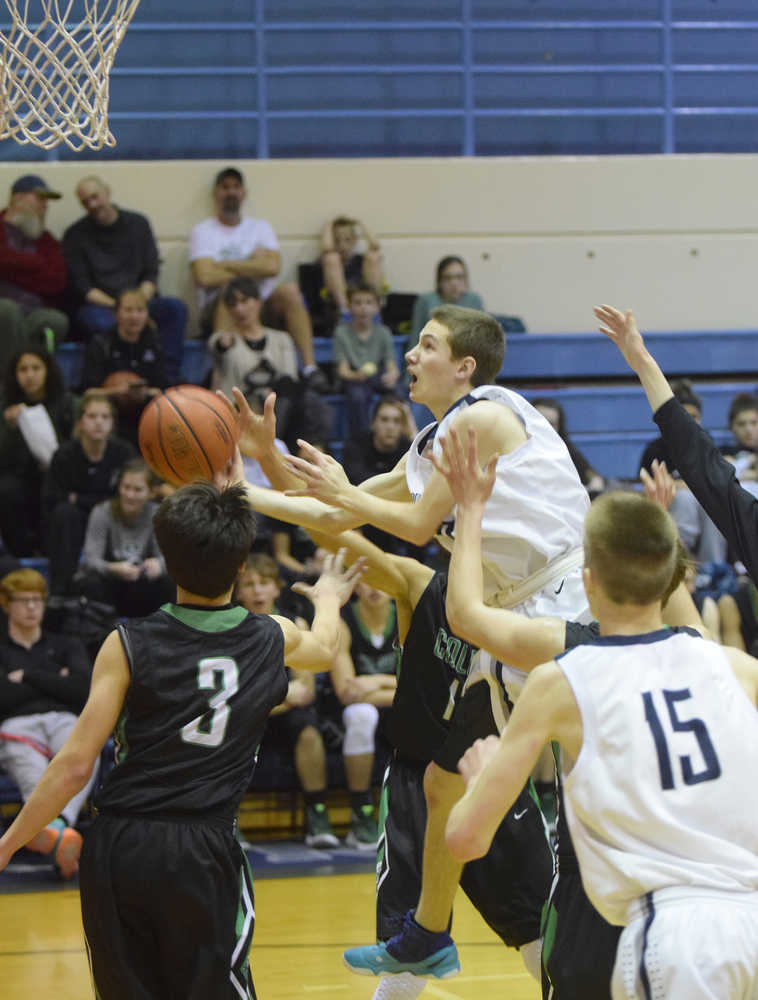 Photo by Joey Klecka/Peninsula Clarion Soldotna guard Caleb Spence splits a few Colony defenders for a layup Saturday at Soldotna High School. The Stars beat the Knights 63-49.