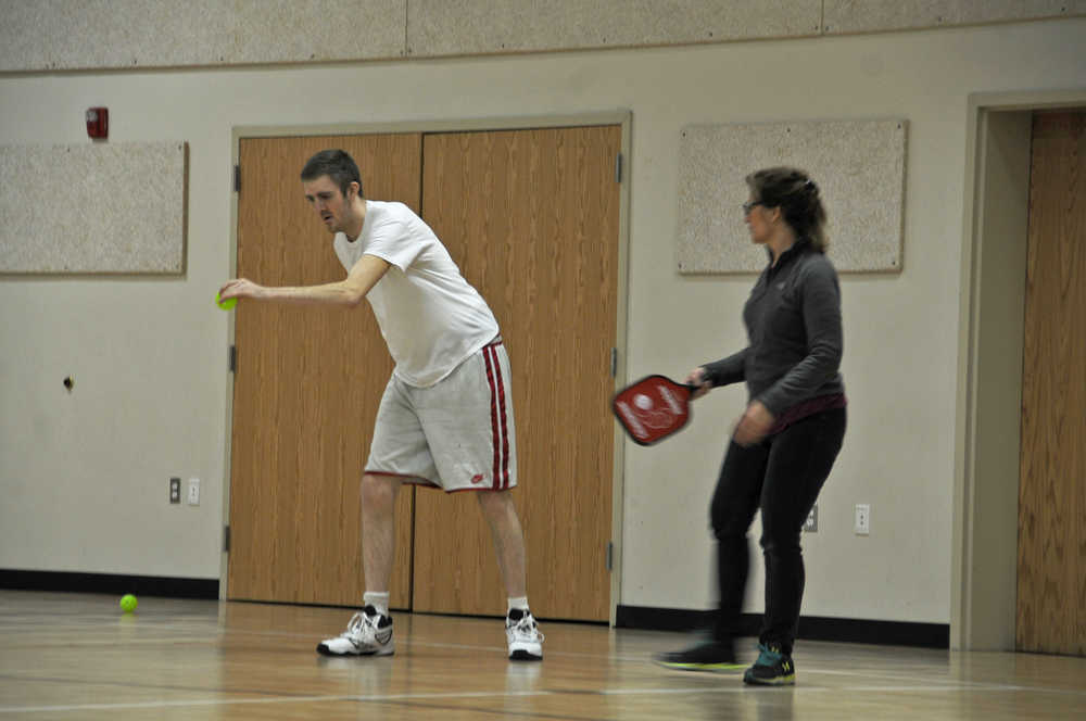 Photo by Elizabeth Earl/Peninsula Clarion Tony Kaser (left) gets coaching from Juanita Owens (right) before serving in a game of pickleball at the Sterling Community Center Feb. 18.