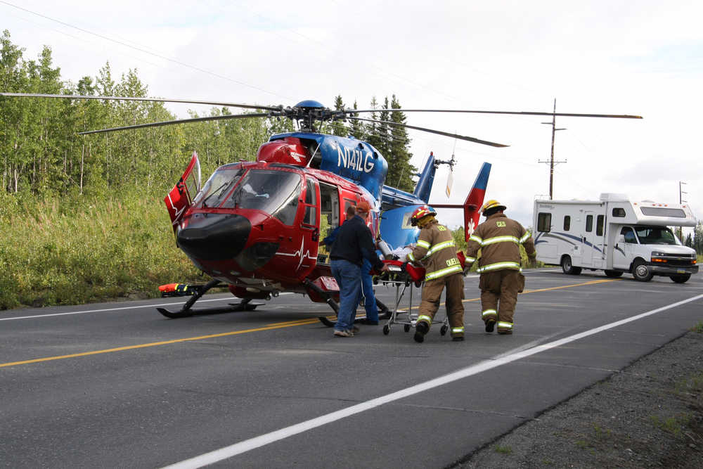 CES Captain Lesley Quelland and other first responders prepare a patient to be transported from the sight of a motor vehcile collision on the Sterling Highway.