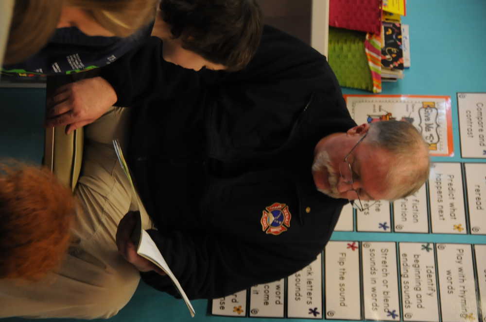 Photo by Elizabeth Earl/Peninsula Clarion Sergeant Roy Smith of the Alaska Department of Corrections reads to a class at Mountain View Elementary School in Kenai during the annual community reading event on Feb. 26, 2016.