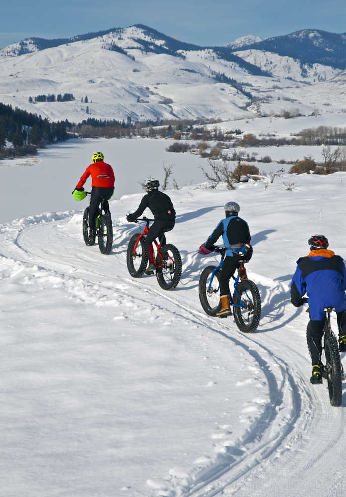 ADVANCE FOR WEEKEND EDITIONS, JAN. 16-17- In this photo taken Jan. 1, 2015, Washington State Park volunteer Dave Acheson leads a group of fat tire bike riders along Rex Derr Trail overlooking Pearrygin Lake near Winthrop, Wash. (Stephen Mitchell via AP)
