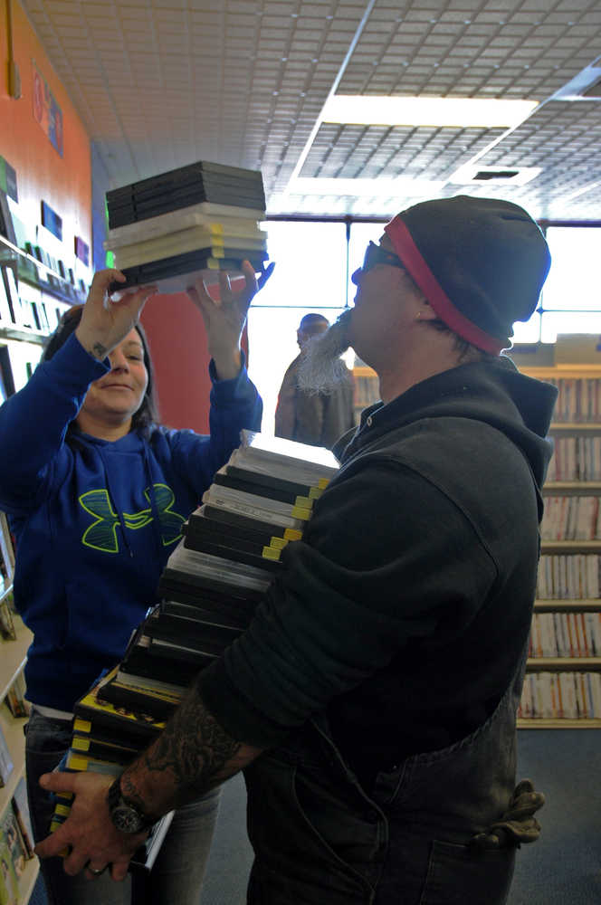 Adam Jones of Soldotna loads up on the Sons of Anarchy DVDs during the Kenai Blockbuster's closing sale on Wednesday, March 2, 2016. The store, which has been open for about 15 years, will close next month.