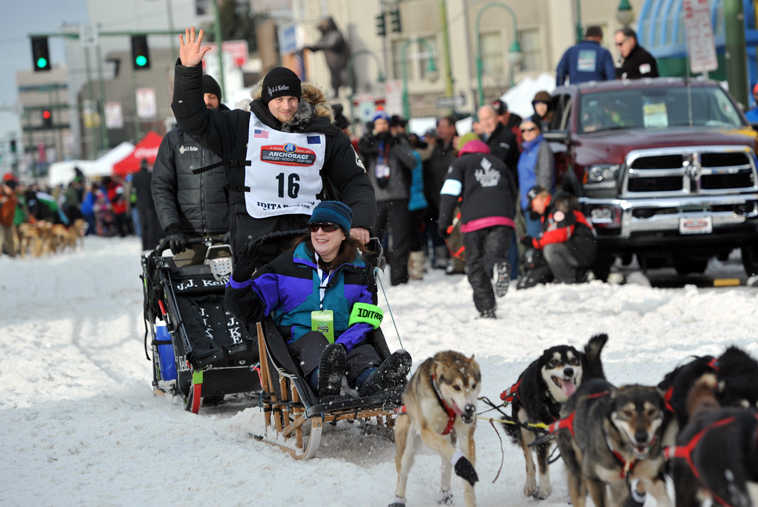 Defending Iditarod Trail Sled Dog Race champion Dallas Seavey (16) waves to the crowd as she begins the ceremonial start of the 1,000-mile race in Anchorage, Alaska, Saturday, March 5, 2016. (AP Photo/Michael Dinneen)