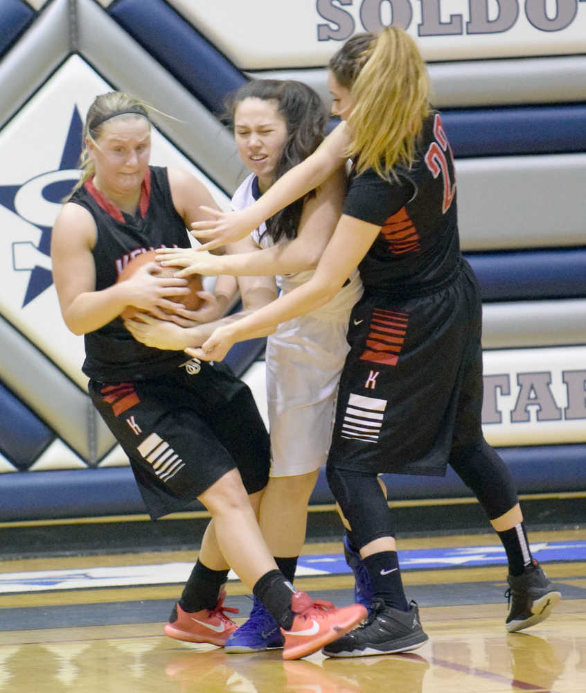 Photo by Jeff Helminiak/Peninsula Clarion Kenai Central's Hannah Drury rips the ball from Soldotna's Melia Miller as Kenai's Alexis Baker helps Saturday at Soldotna High School.