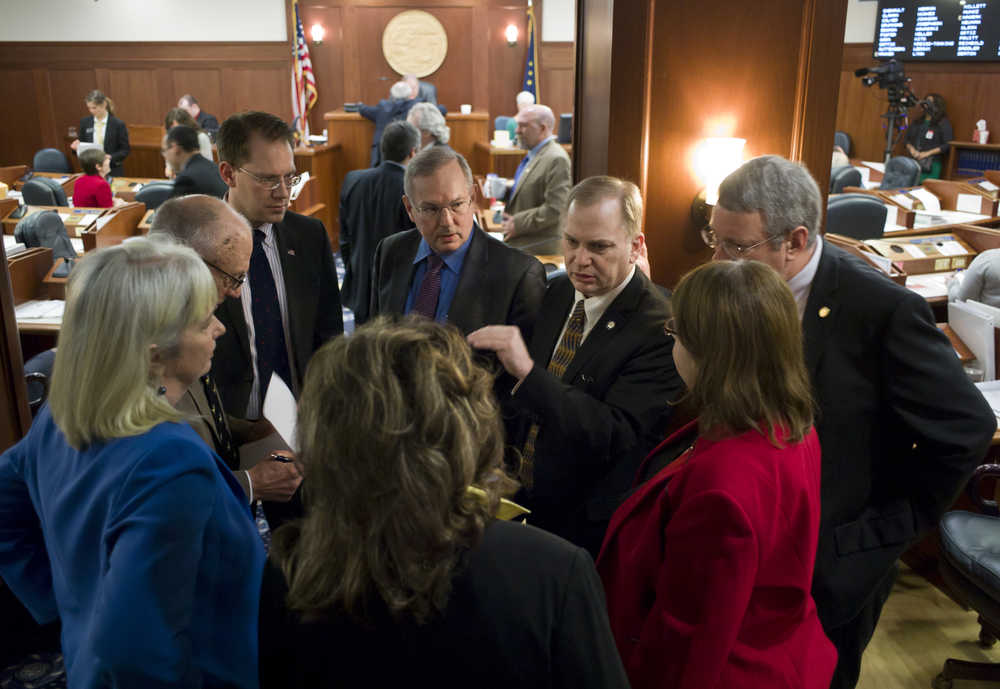 Members of the House Majority Caucus hold a huddle at the back of the House's chambers while working on amendments to the operating budget on Thursday.