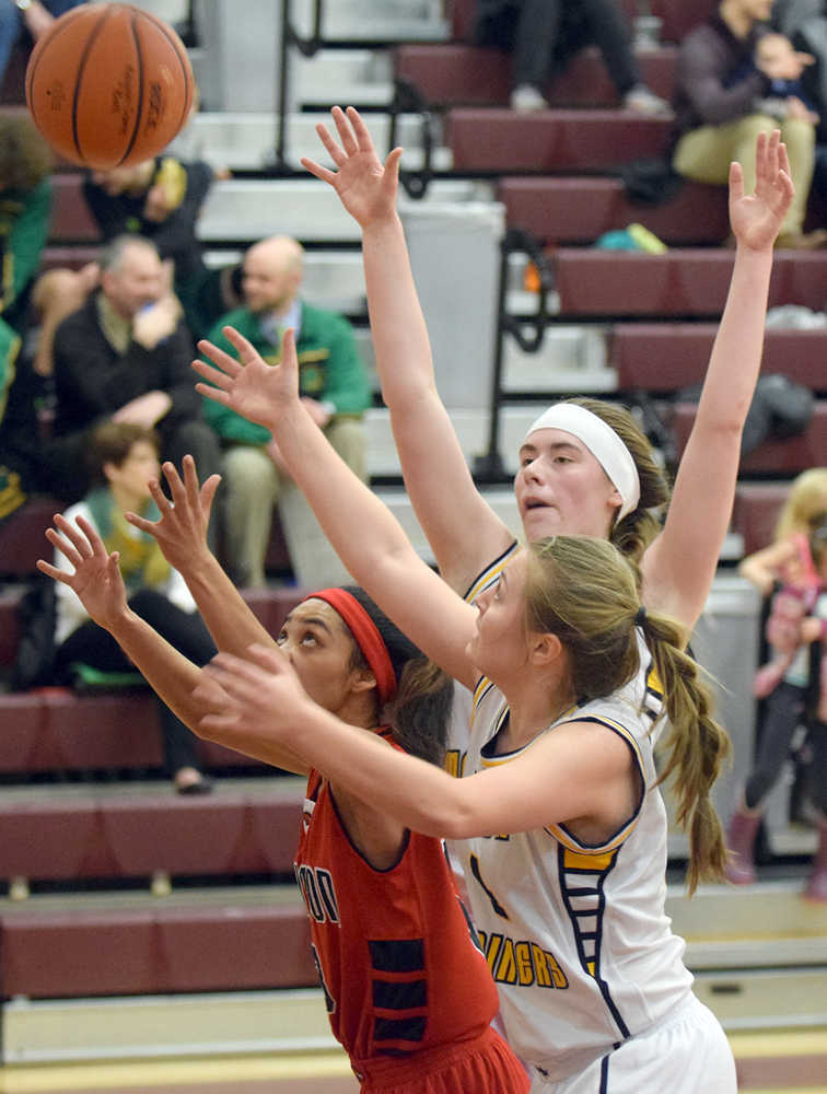 Photo by Joey Klecka/Peninsula Clarion Houston guard Chanel May-Thomas (left) and Homer forwards Madison Akers and Uliana Reutov battle for a rebound in Friday's semifinal contest at the Southcentral Conference tournament at Grace Christian High School.