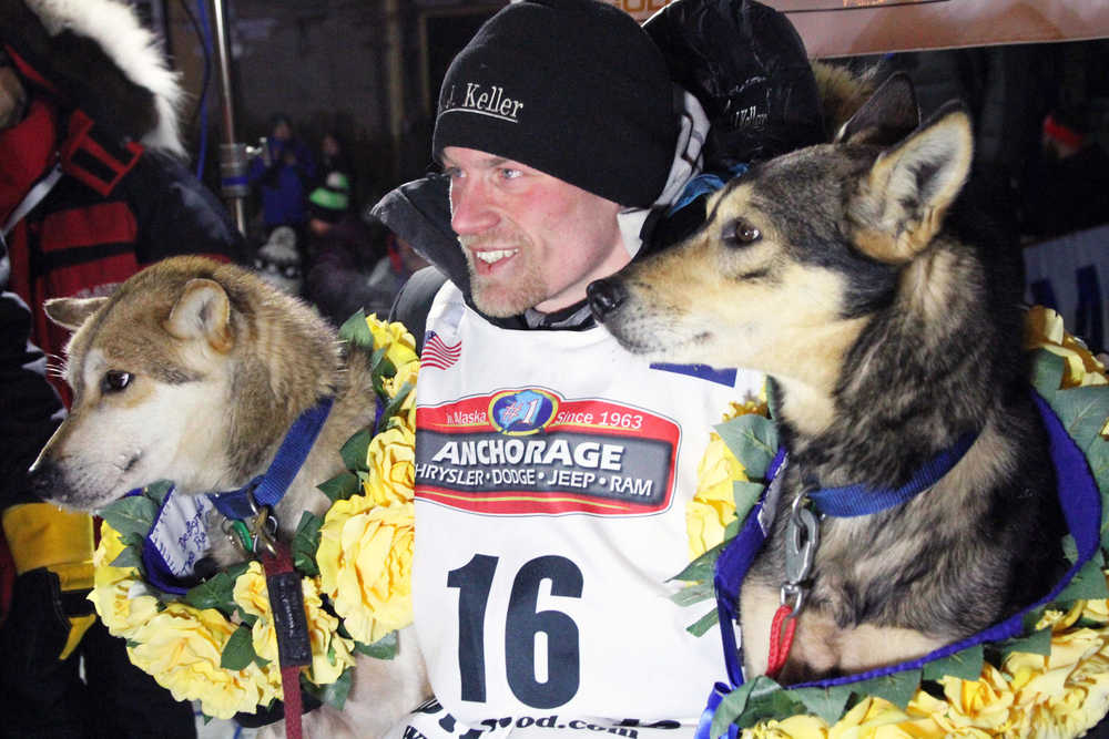 Dallas Seavey poses with his lead dogs Reef, left, and Tide after finishing the Iditarod Trail Sled Dog Race, Tuesday, March 15, 2016,  in Nome, Alaska. Seavey won his third straight Iditarod, for his fourth overall title in the last five years. (AP Photo/Mark Thiessen)