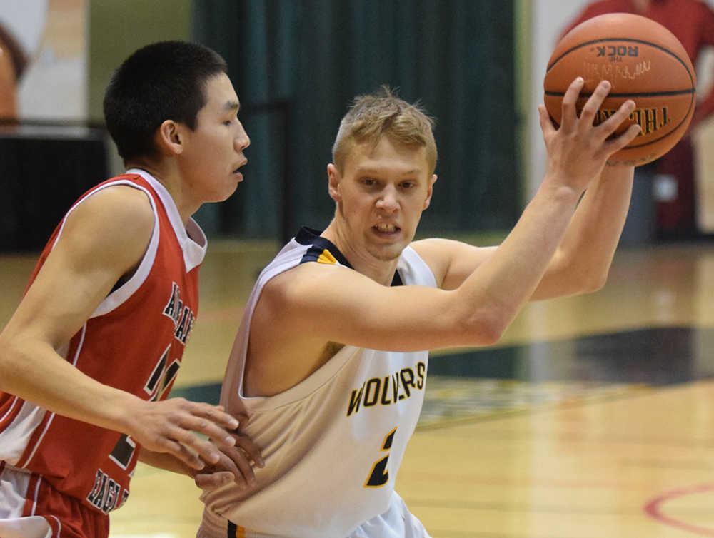 Photo by Joey Klecka/Peninsula Clarion Ninilchik guard Tyler Presley looks for a way around St. Mary's defender Mitchell Luke Wednesday at the Class 1A March Madness state tournament at the Alaska Airlines Arena in Anchorage.