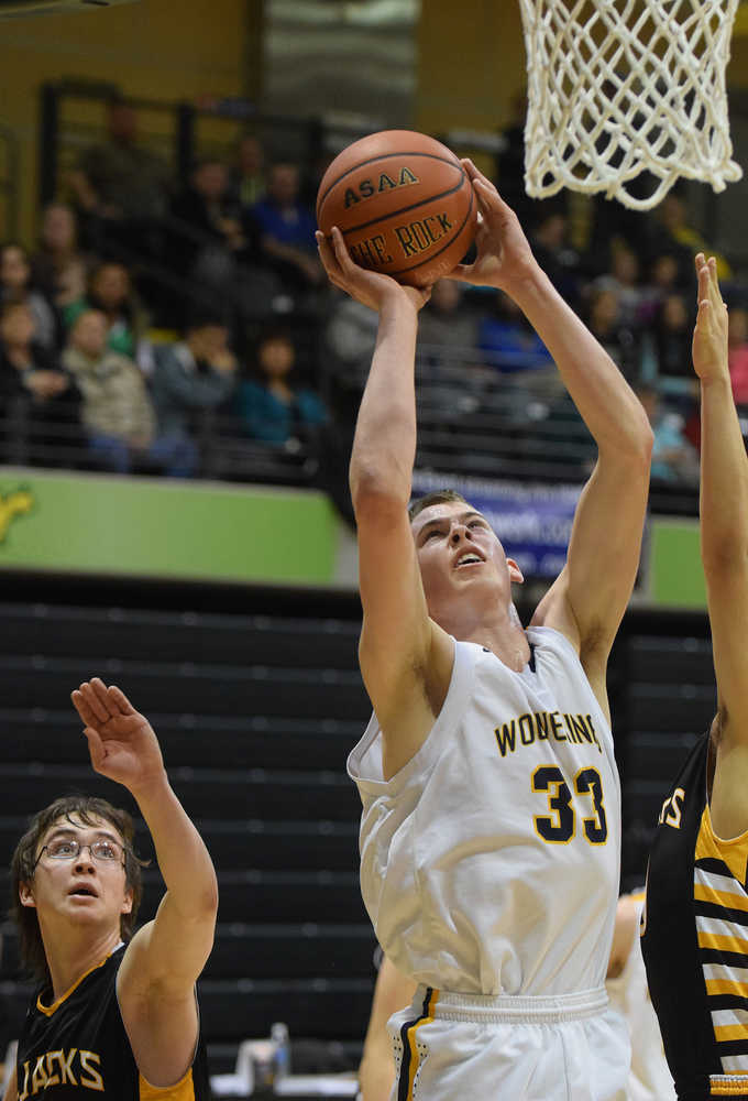 Photo by Joey Klecka/Peninsula Clarion Ninilchik forward Austin White (33) shoots amid a scrum of King Cove defenders Thursday at the Class 1A March Madness state tournament at the Alaska Airlines Arena in Anchorage.