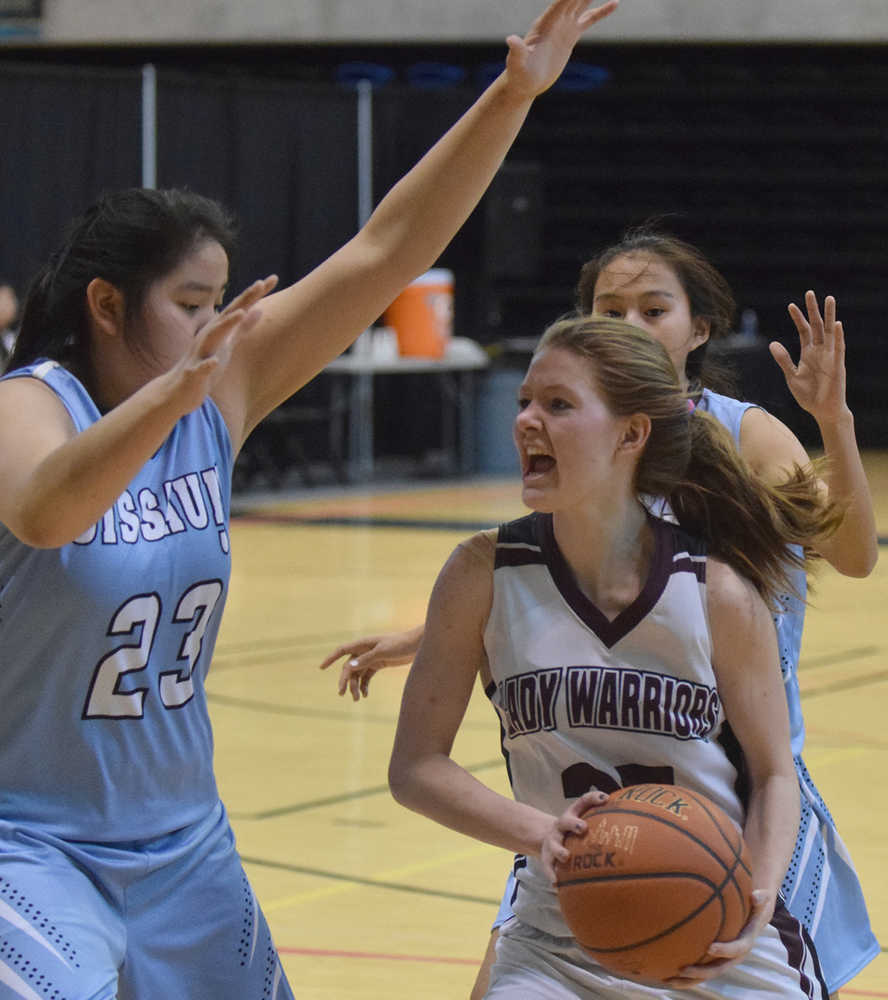 Photo by Joey Klecka/Peninsula Clarion Nikolaevsk senior guard Megan Hickman drives to the rim against Buckland defender Rosaline Hadley Thursday at the Class 1A March Madness state tournament at the Alaska Airlines Center in Anchorage.