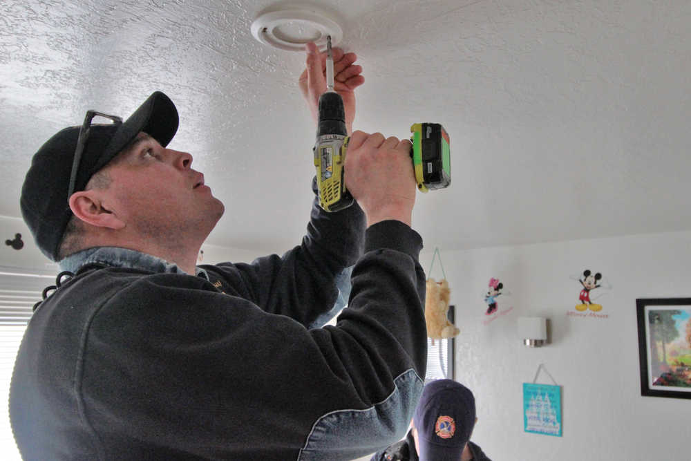 Lilac Lane resident Jared Clay (left) talks with Kenai Fire Marshal Tommy Carver about his apartment's smoke detectors and his family's fire escape on Saturday, March 19 in Kenai. Carver and other members of the Kenai Fire Department, along with volunteers from the American Red Cross, were going door-to-door Saturday to install free smoke detectors in homes.