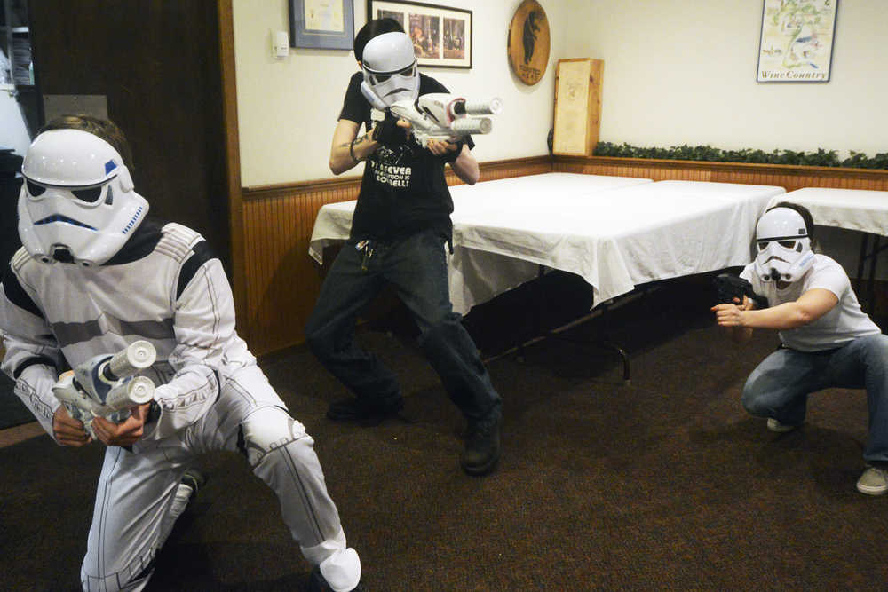 Photo by Megan Pacer/Peninsula Clarion Members of the Triumvirate Theatre group burst through a door while rehearsing for their upcoming performance of "Fish Wars: A Humpy Rises," on Tuesday, March 22, 2016 at Mykel's Restaurant in Soldotna, Alaska. The annual dinner theatre and auction puts a fishy spin on a well-known film and incorporates local events and issues.