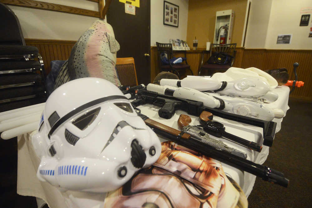 Photo by Megan Pacer/Peninsula Clarion Props ranging from a storm trooper mask to a stuffed fish named "Wappy" cover a table in preparation for a Triumvirate Theatre rehearsal on Tuesday, March 22, 2016 at Mykel's Restaurant in Soldotna, Alaska. The group will perform the latest of its annual dinner theatre and auction events, "Fish Wars: The Humpy Rises," beginning March 25.