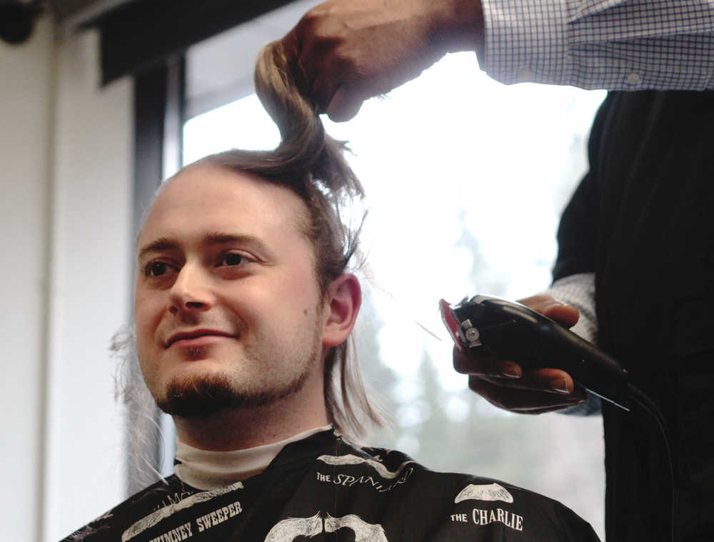 A volunteer's head is shaved by barber Alexander Walton of Glacier City Barbershop during a St. Baldrick's Foundation head-shaving fundraiser on Thursday, March 24 at Kenai Peninsula College.
