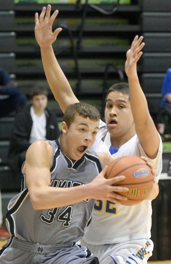 Photo by Joey Klecka/Peninsula Clarion Nikiski senior Nathan Carstens drives along the baseline against Barrow defender Kekoa Ahgeak in Thursday's Class 3A boys state quarterfinal at the Alaska Airlines Center in Anchorage.