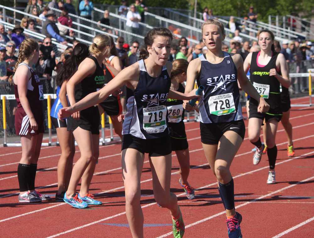 Photo by Joey Klecka/Peninsula Clarion Soldotna junior Daisy Nelson (728) hands off to Stars teammate Olivia Hutchings (719) in the girls 3,200-meter relay at the Class 4A state meet May 30, 2015. Hutchings and Nelson were joined by seniors Sadie Fox and Dani McCormick to set a new state record in the event.