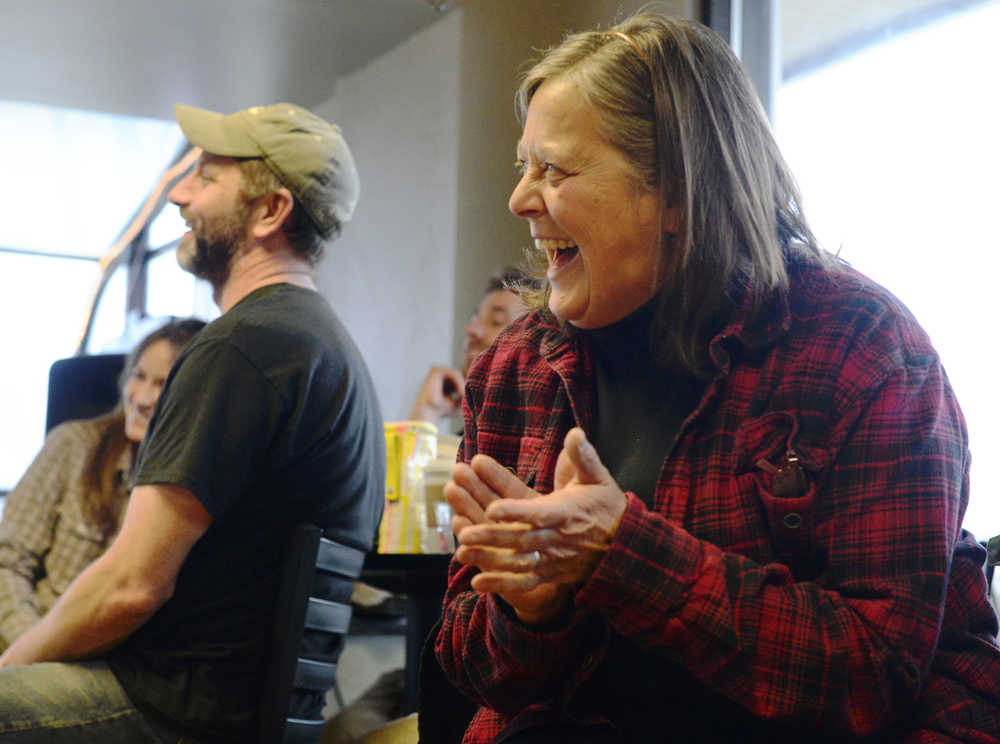 Audience members react to a story told by Bill Holt during a storytelling evening on Friday, April 1 at Odie's Deli.