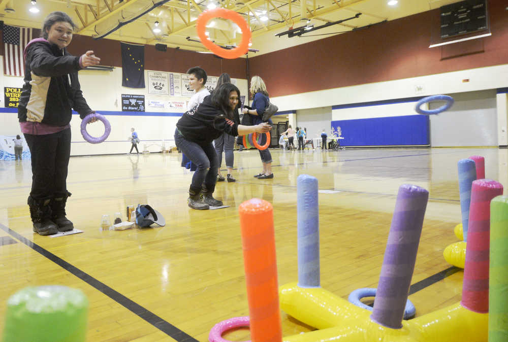 Jordan Tackett (left) plays a ring-toss game against her mother during the Autism Extravaganza awareness fair at Soldotna Preparatory School on Saturday, April 4. Tackett, who is autistic, was among those who came to play games and socialize during the event.