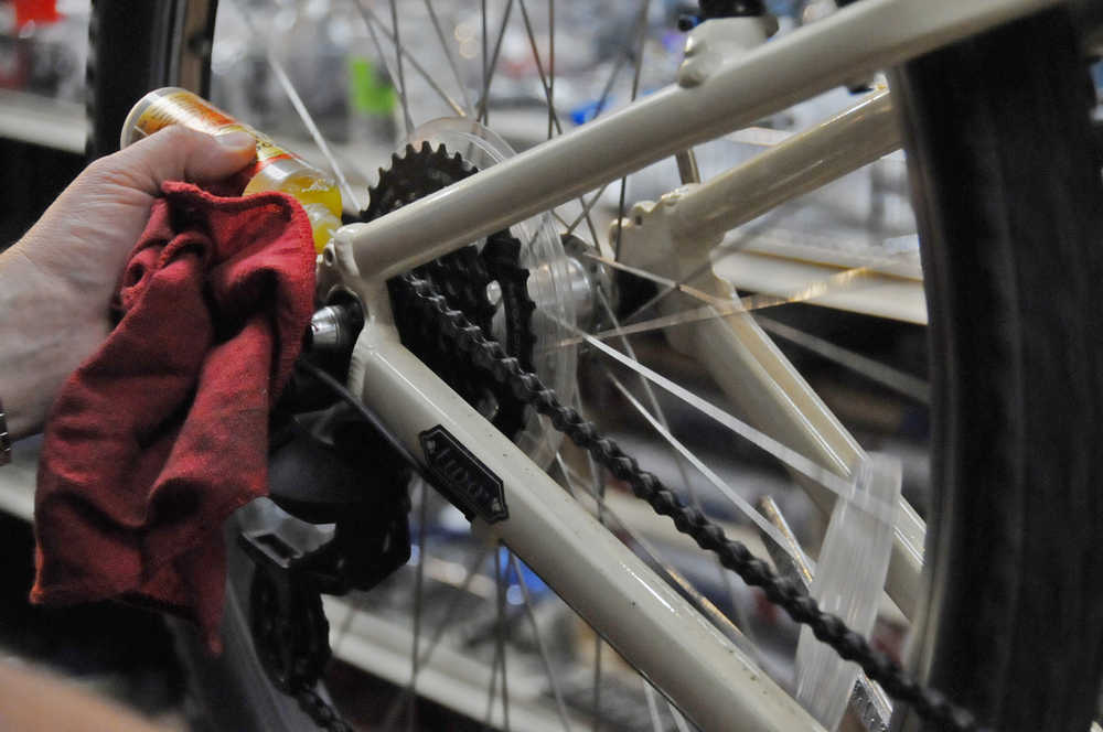 Photo by Elizabeth Earl/Peninsula Clarion Brad Carver of Beemun's Bike and Ski Loft lubes a bike chain as part of a spring tune-up on Tuesday, March 29, 2016.