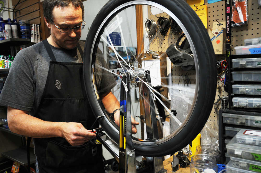 Photo by Elizabeth Earl/Peninsula Clarion Brad Carver, a mechanic at Beemun's Bike and Ski Loft in Soldotna, trues the front wheel of a bike during a spring tune-up on Tuesday, March 29, 2016.