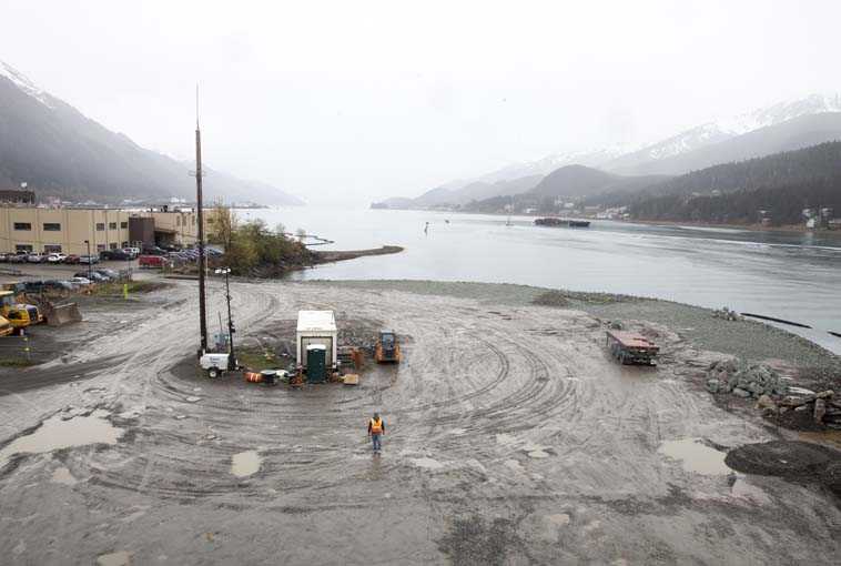 A city worker walks along a site that will soon host a life-sized whale sculpture and bridge park project along the Gastineau Channel Tuesday in Juneau, Alaska. The city is being sued by a industry representative for 12 cruise lines which alleges that the city is misspending funds from a per-passenger tax on the whale project and others which do not directly benefit cruise passengers.  (AP Photo/Rashah McChesney)