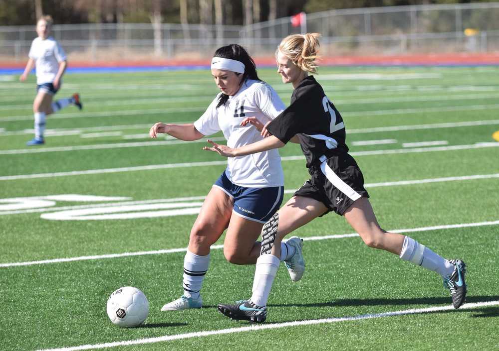 Photo by Joey Klecka/Peninsula Clarion Soldotna's Sarah Federle (left) battles for the ball against Nikiski's Molly Cason Tuesday at Soldotna High School.