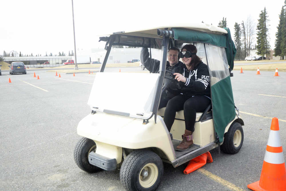 Photo by Megan Pacer/Peninsula Clarion Trevor Debnam drives through an obstacle course while texting on his phone under the supervision of Kenai Police Officer Alex Prins during an exercise Wednesday, April 13, 2016 at Kenai Central High School in Kenai, Alaska. Students completed the driving drill as part of a unit in their health class.