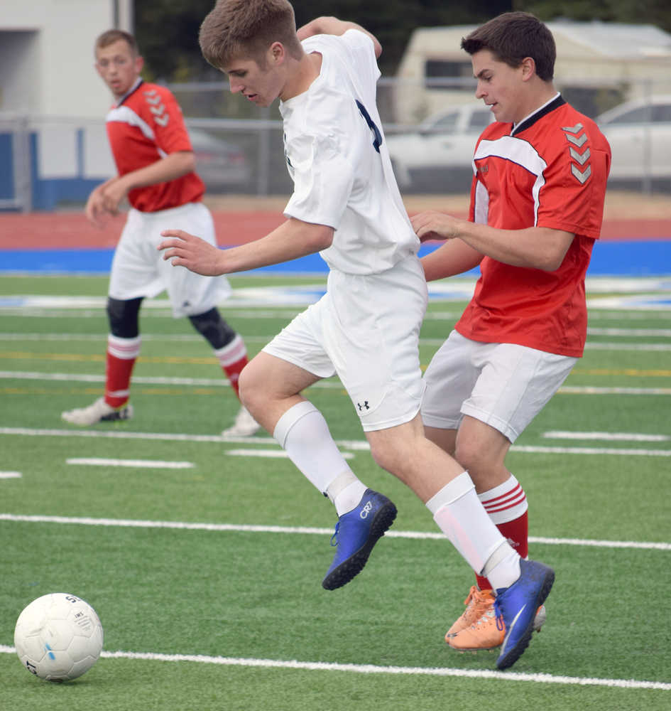 Photo by Jeff Helminiak/Peninsula Clarion Soldotna's Timmy Smithwick protects the ball from Kenai Central's Max Dye on Thursday, April 14, 2016, at Soldotna High School.