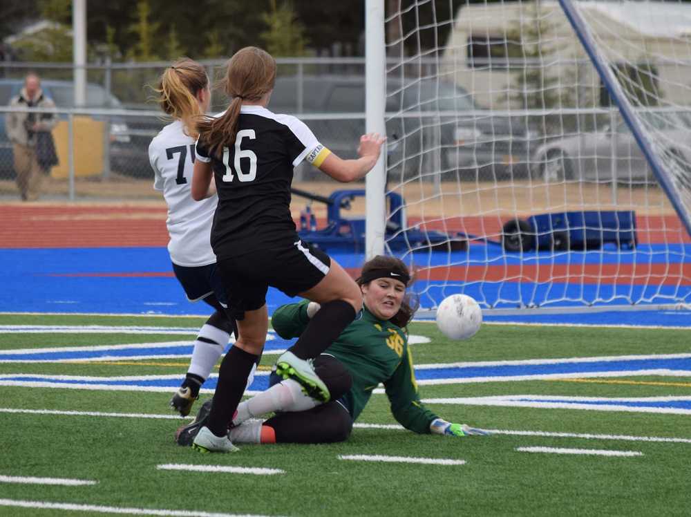 Photo by Joey Klecka/Peninsula Clarion Soldotna goalkeeper Maddie Kindred (36) dives to block a shot by South Anchorage's Megan Currier (16) with SoHi teammate Talon Hagen in tow, Friday at Soldotna High School.