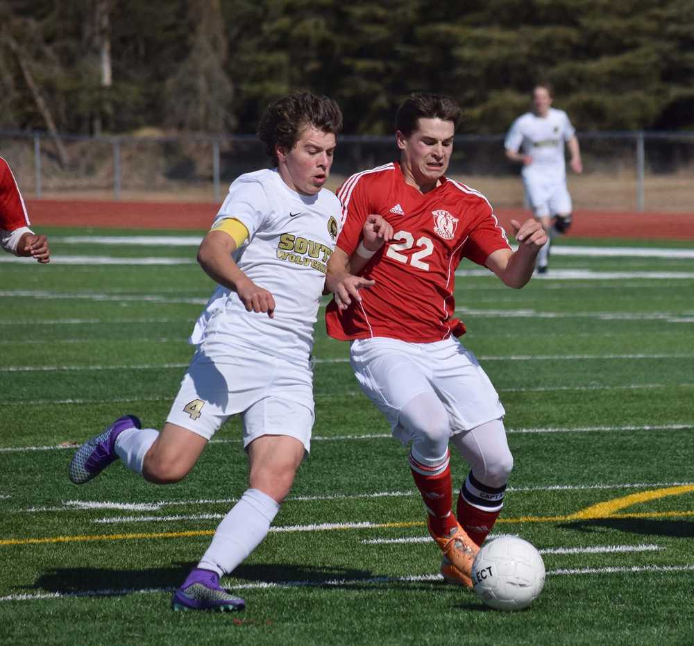 Photo by Joey Klecka/Peninsula Clarion Kenai Central defender Max Dye (22) battles with South Anchorage's Blake Hepler Saturday afternoon at Ed Hollier Field in Kenai.