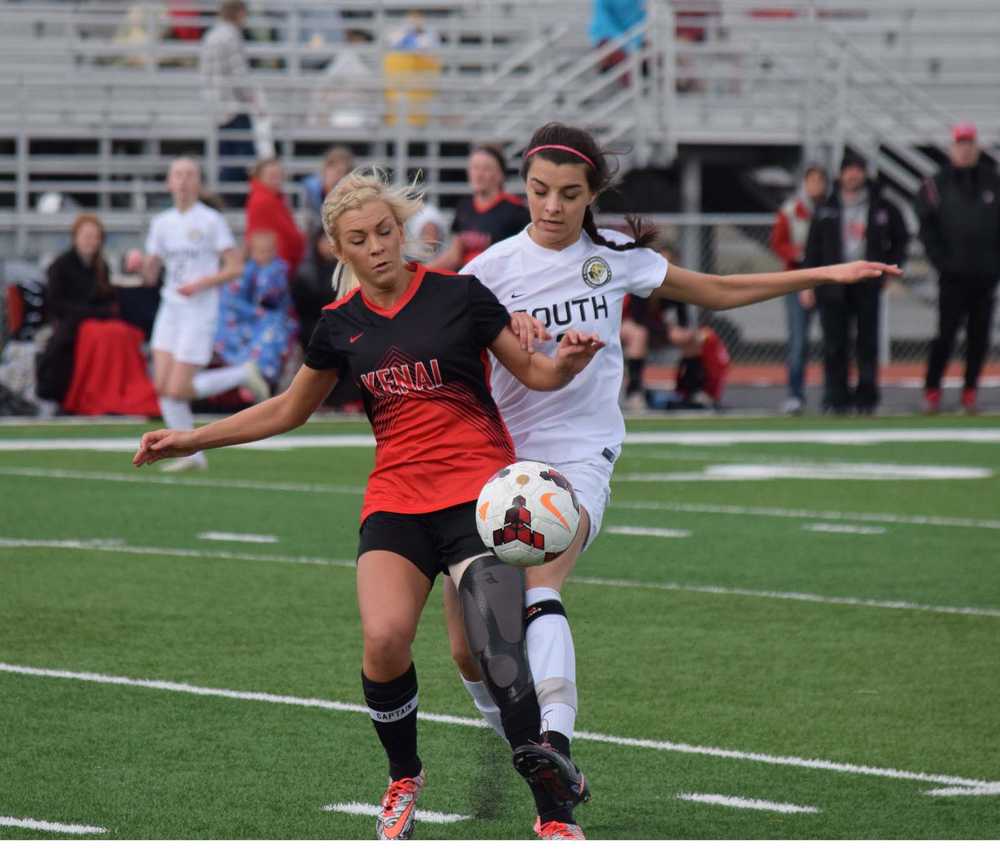 Photo by Joey Klecka/Peninsula Clarion Kenai Central sweeper Kylie Morse (left) battles for the ball with South Anchorage's Alex Ott Saturday afternoon at Ed Hollier Field in Kenai.