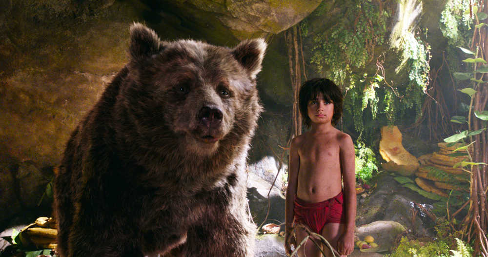 In this image released by Disney, Mowgli, portrayed by Neel Sethi, right, and Baloo the bear, voiced by Bill Murray, appear in a scene from, "The Jungle Book." (Disney via AP)